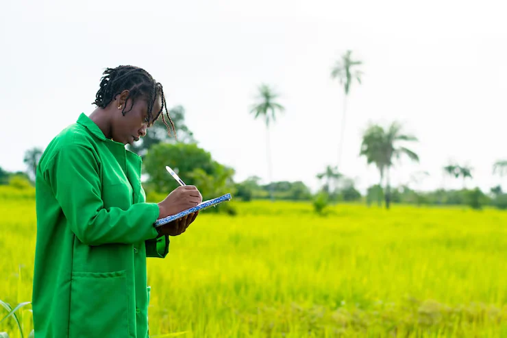 Monitoring and Evaluation officer surveying farmers in rural Africa.