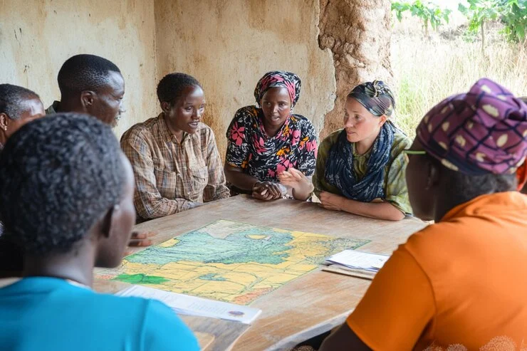 Men and women participating in a community monitoring and evaluation session