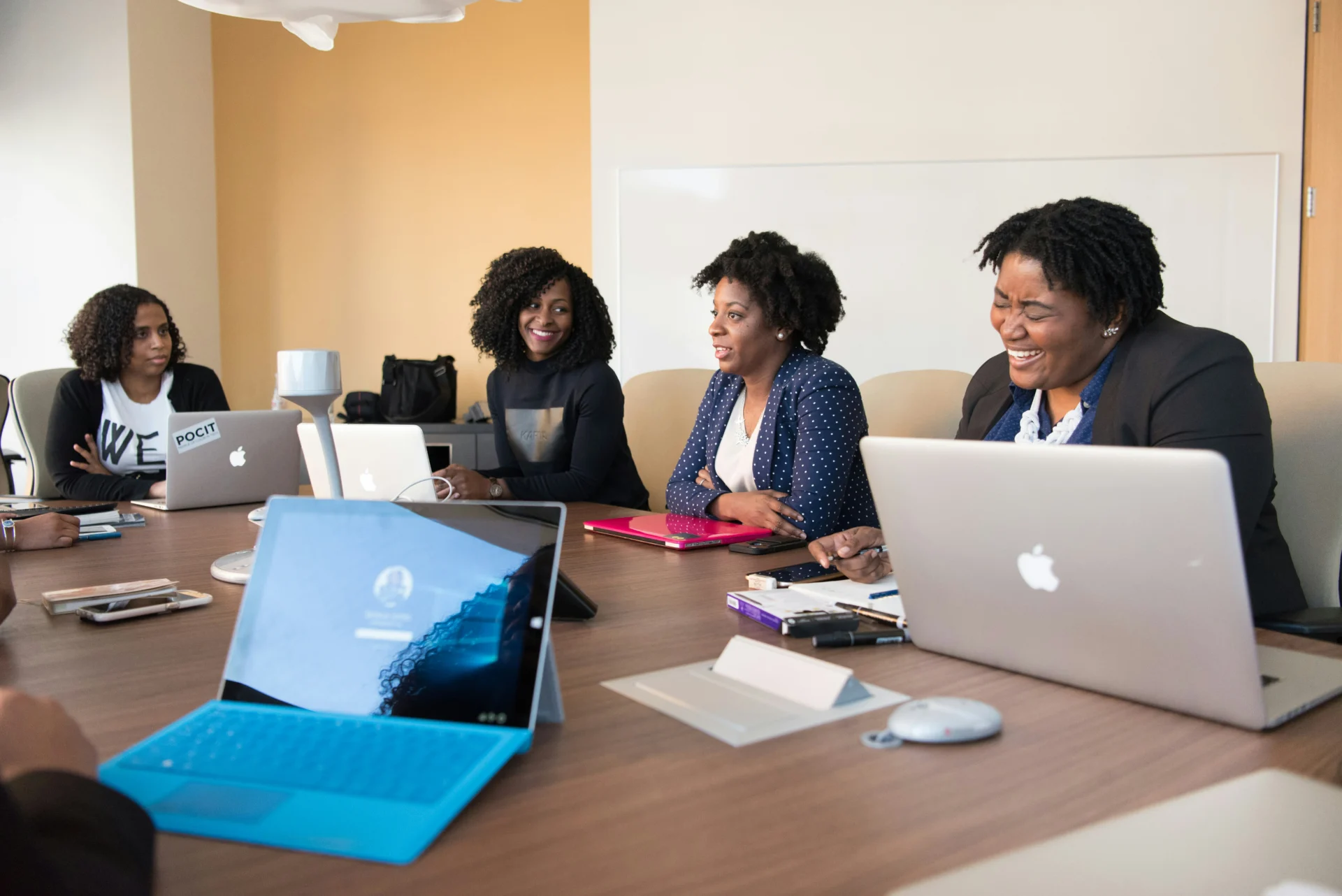 Group of women with digital devices participating in an inclusive, SDG-aligned evaluation meeting