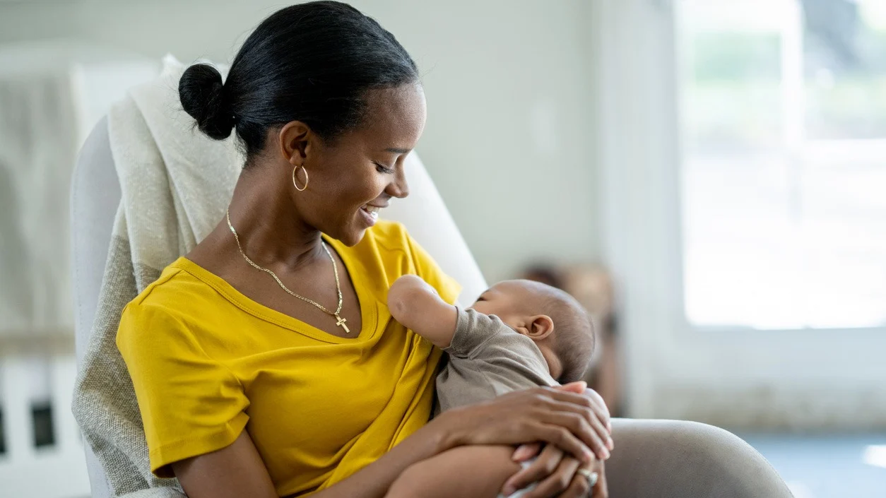 Mother breastfeeding her newborn during World Breastfeeding Week 2026