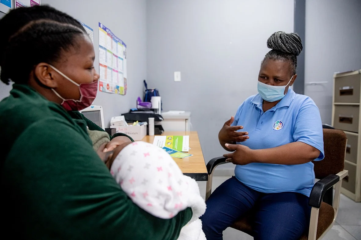 African healthcare worker supporting a breastfeeding mother