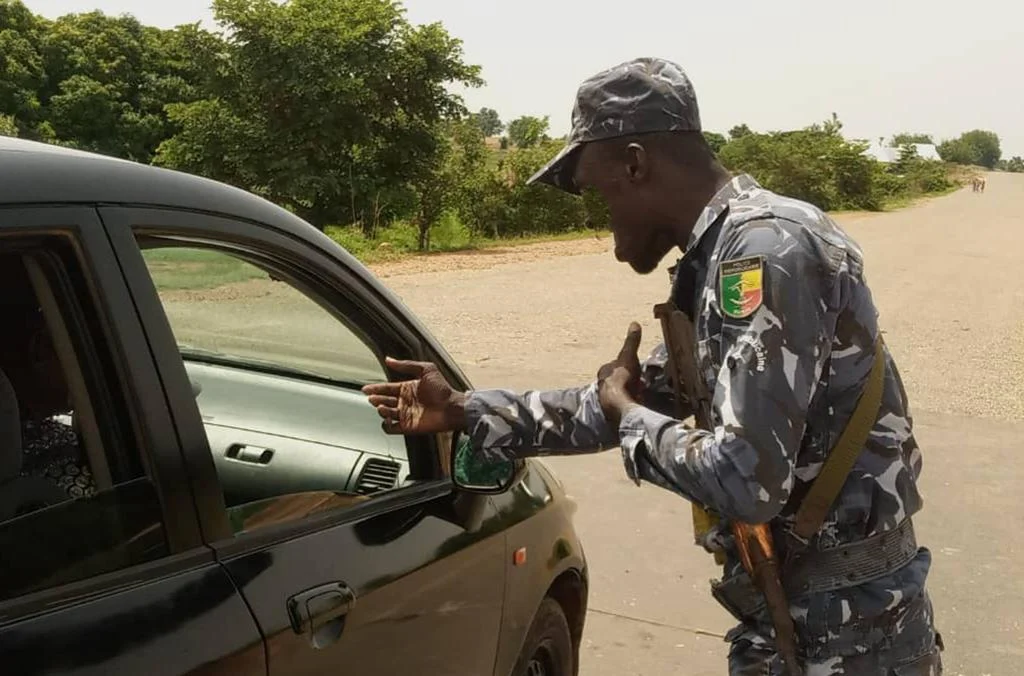 African police officer interacting with a citizen, representing the relationship between policing, public trust and corruption.